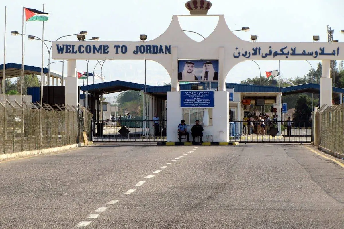 Private luxury sedan approaching Jordan border crossing gate